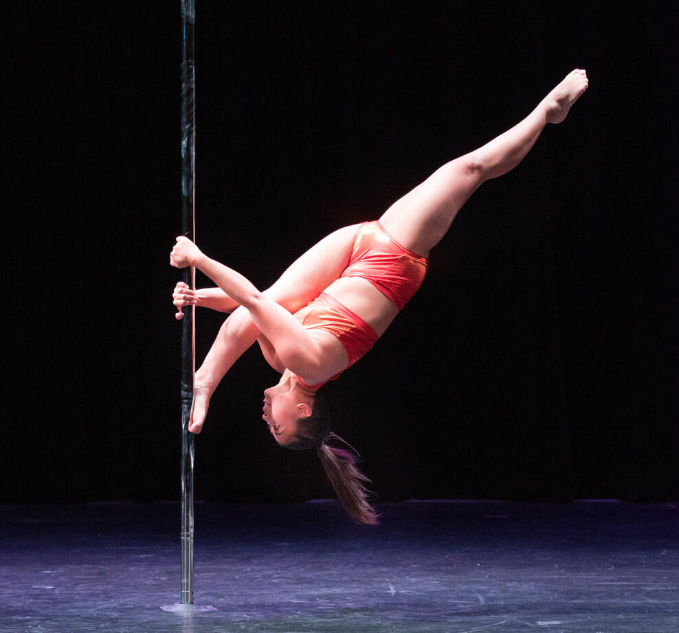 I'm upside down with one foot and both hands on a pole with my other leg extended in a Russian split